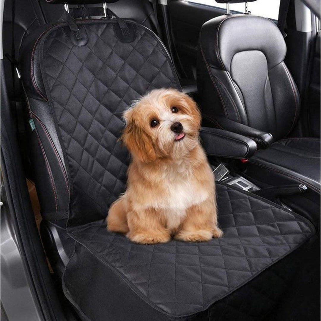 Perro café sentado sobre el asiento para perro usado en modo plano, cubriendo el asiento completo del auto