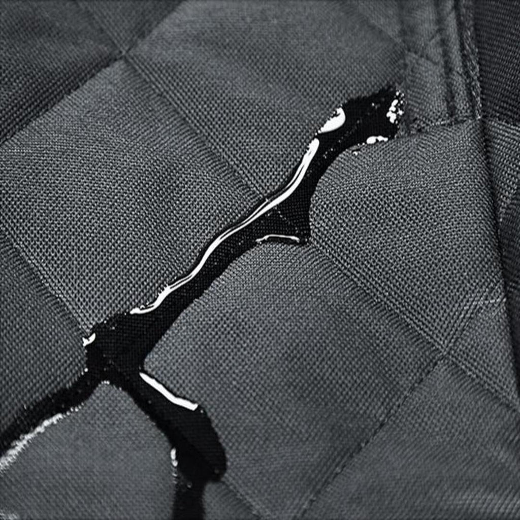 Detalle de la tela acolchada impermeable con gotas de agua sobre la superficie sin absorberse