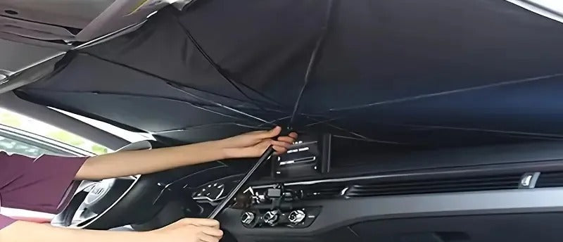 Persona abriendo el parasol tipo paraguas por dentro del parabrisas